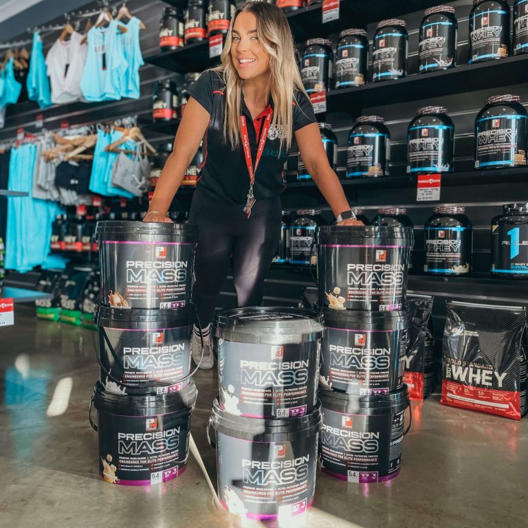 World Gym Employee showing off Precision Mass protein powder