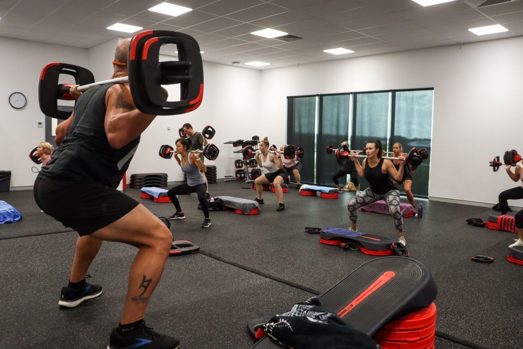 Trainer instructing class on squats