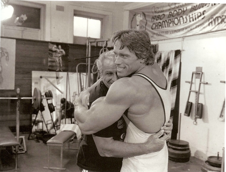 Arnold Schwarzenegger hugging trainer